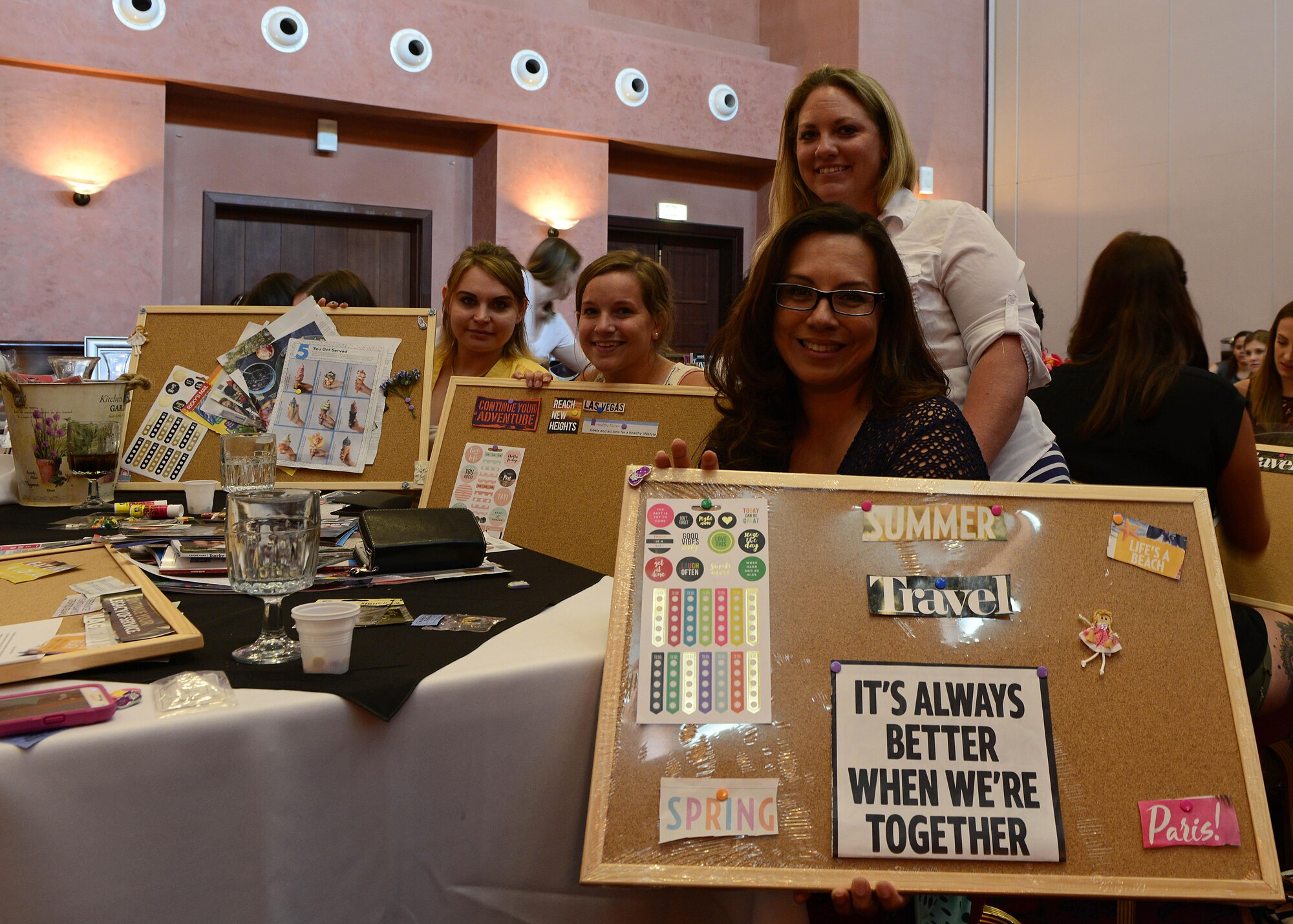 Team Aviano spouses show off the vision boards they made during a spouse appreciation lunch at Aviano Air Base, Italy, and June 1, 2017. The project was designed to help individuals focus on goals and priorities. (U.S. Air Force photo by Airman 1st Class Ryan Brooks)