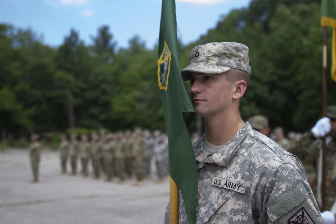 Pvt. First Class Stephen Grams, a U.S. Army Reserve supply clerk with the Headquarters and Headquarters Company, 200th Military Police Command, stands at attention with the unit guideon during a change of command ceremony at Fort Meade, Maryland, June 3. Maj. John Mullaney relinquished command to Cpt. Robert Mark during the ceremony. (U.S. Army Reserve photo by Sgt. Audrey Hayes)