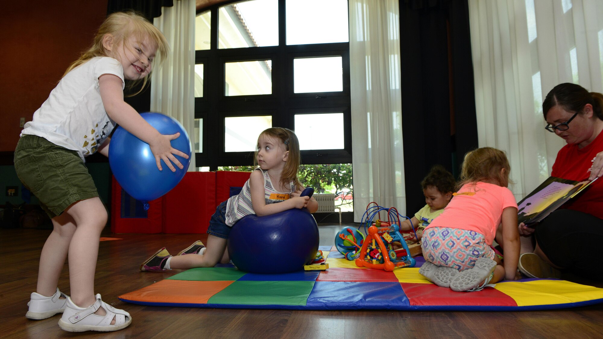 Angela Devine, Child Development Center volunteer (right), provide childcare for parents during a spouse appreciation lunch, at Aviano Air Base, Italy, June 1, 2017. Volunteers provided the children with food, games and balloons during the two-hour event. (U.S. Air Force photo by Airman 1st Class Ryan Brooks)