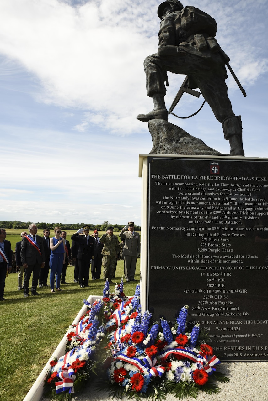 U.S., German and French dignitaries salute as ‘Taps’ is played, June 4, 2017, during the ‘Iron Mike’ wreath-laying ceremony in Sainte-Mere-Eglise, France. This ceremony commemorates the 73rd anniversary of D-Day, the largest multi-national amphibious landing and operational military airdrop in history, and highlights the U.S.’ steadfast commitment to European allies and partners. Overall, approximately 400 U.S. servicemembers from units in Europe and the U.S. are participating in ceremonial D-Day events from May 31 to June 7, 2017.