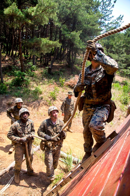 Marines and sailors climb a wall obstacle during a small unit leadership building course at Camp Mujuk, South Korea, May 29, 2017. Marine Corps photo by Lance Cpl. Caleb T. Maher
