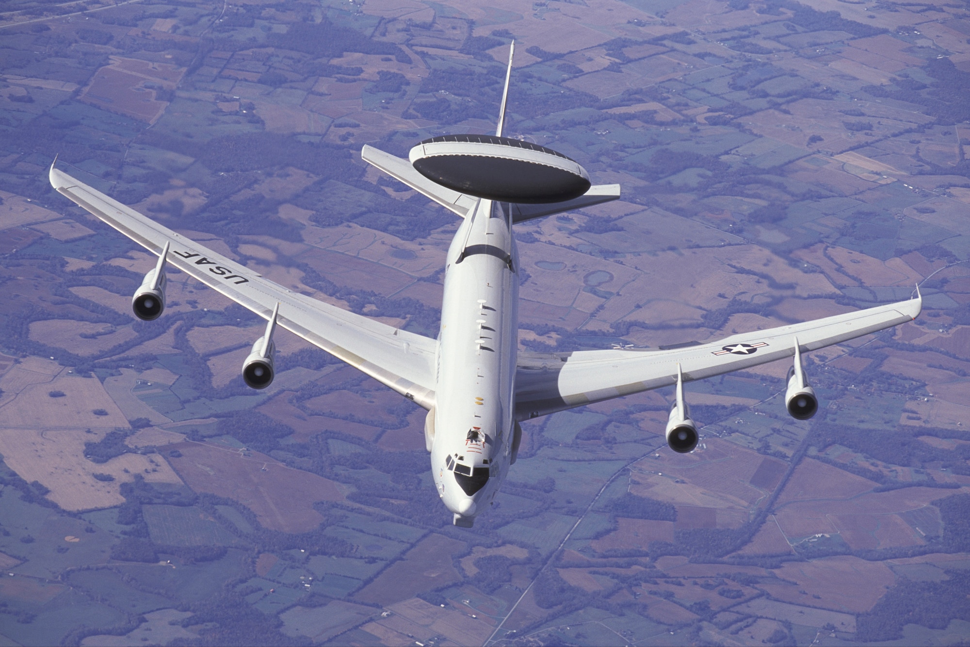 Overall view of a 552nd Air Control Wing E-3C Airborne Warning & Control System (AWACS) aircraft shown over the central United States as it approaches a KC-135R Stratotanker to refuel.  The AWACS aircraft has a large rotating radar mounted above the aircrafts' fuselage and large sensors mounted along the sides of the forward fuselage and below the nose. The E-3C is based at Tinker Air Force Base, Oklahoma. Copyright 2003 Greg L. Davis, Aviation Photojournalist