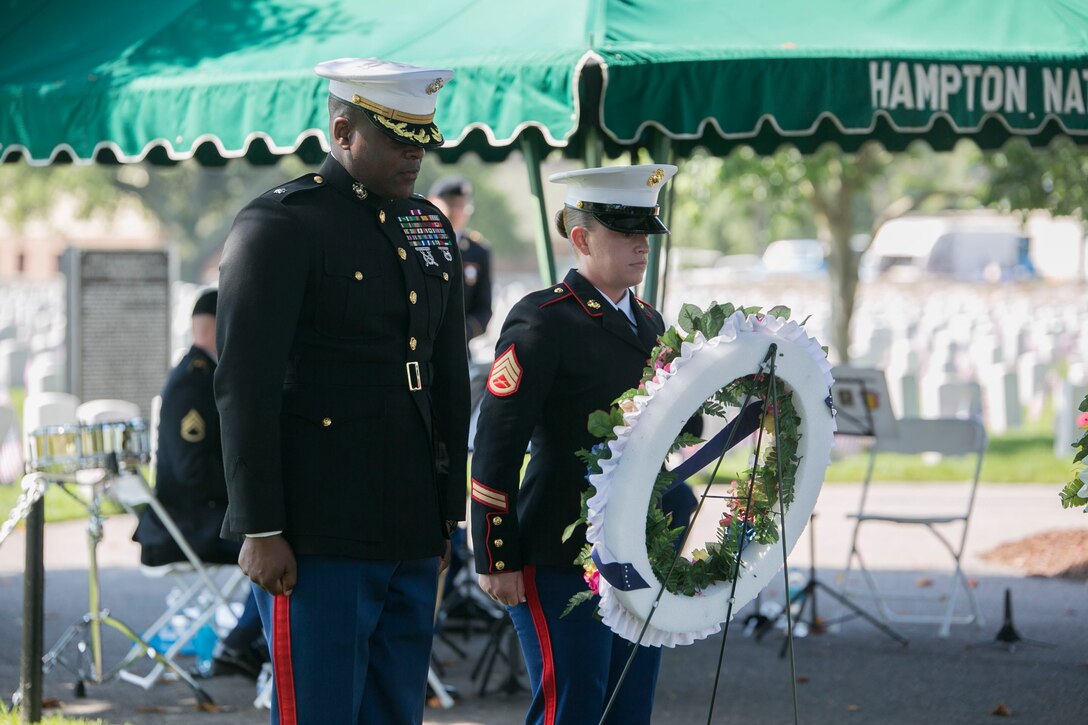 Lt. Col. Wade Wallace, executive officer, Headquarters and Service Battalion, U.S. Marine Corps Forces Command, and Staff Sgt. Stephanie Lampear, staff noncommissioned officer-in-charge, Installation Personnel Administration Center, H&S Battalion, MARFORCOM, place one of six wreaths upon the grave of a deceased service member at Hampton National Cemetery, May 29, in Hampton, Va.. The placing of wreaths by service members of each military branch was conducted to pay respect to the fallen and honor their memory on Memorial Day. (Official U.S. Marine Corps photo by Cpl. Logan Snyder/ Released)
