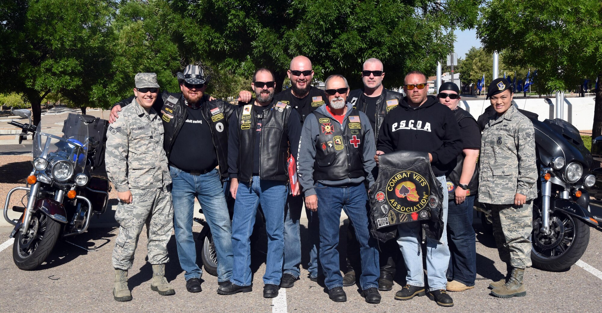 Members of the Combat Veterans Motorcycle Association pose with Team Kirtland airmen at the New Mexico Veterans Memorial, May 30, 2017. The veterans rode over to the New Mexico Veterans Memorial, where they had a chance to remember the fallen with Kirtland airmen and allow the airmen to sign flags that the group was carrying. (U.S. Air Force Photo/Joanne Perkins)