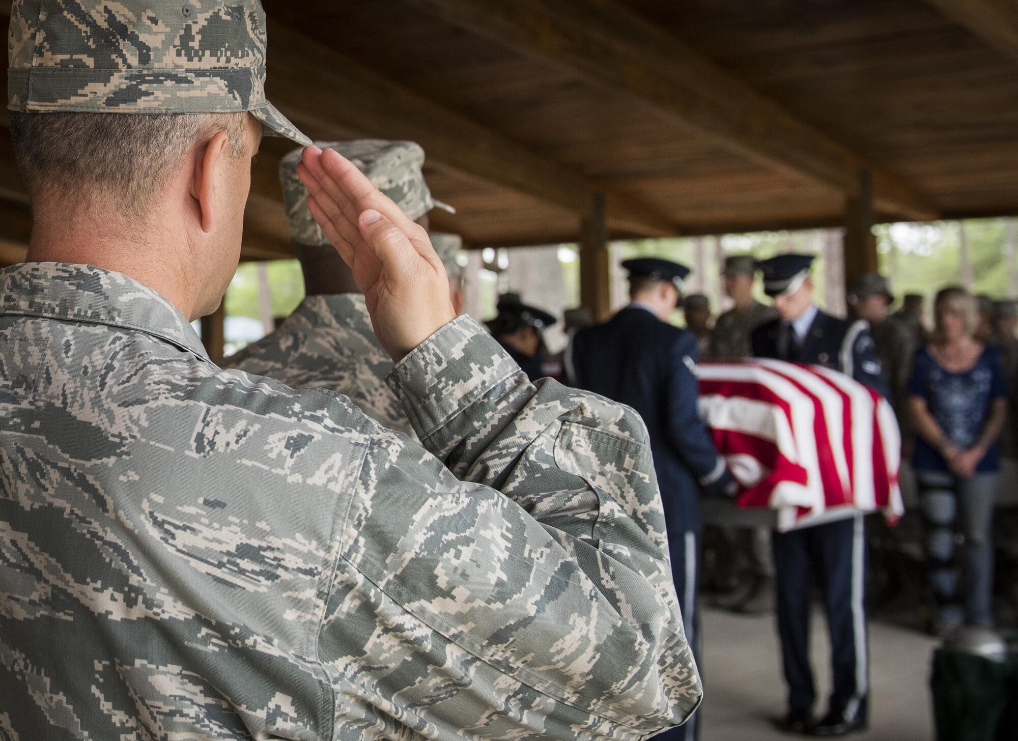 Team Eglin leadership salutes as the casket is carried in at the Honor Guard graduation ceremony at Eglin Air Force Base, Fla., June 1. Approximately 12 new Airmen graduated from the 120-plus-hour course. The graduation performance includes flag detail, rifle volley, pall bearers and bugler for friends, family and unit commanders. (U.S. Air Force photo/Samuel King Jr.)
