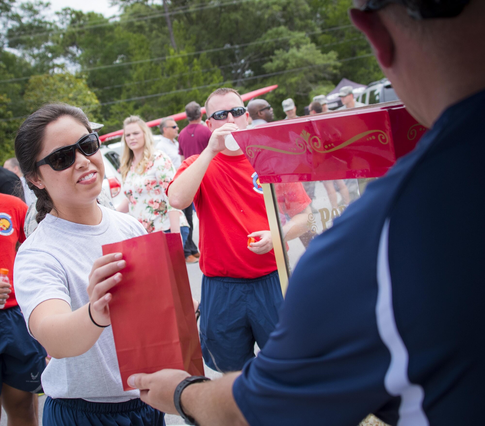 An Airman receives a bag of popcorn from a vendor during the Eglin Connects event at Eglin Air Force Base, Fla., June 2.  The event to help promote resiliency featured information booths, sporting events and a car show.  (U.S. Air Force photo/Samuel King Jr.)