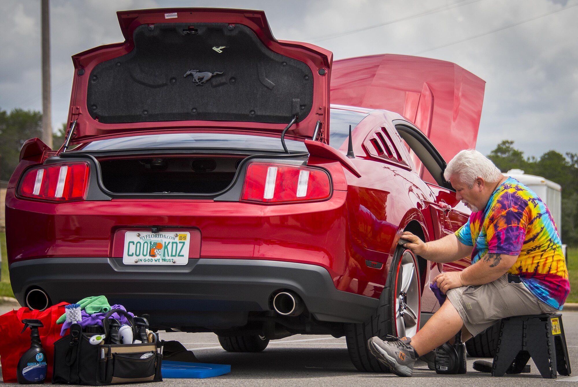 A Mustang owner ensures his tire are clean and shiny during the Eglin Connects event at Eglin Air Force Base, Fla., June 2.  The event to help promote resiliency featured information booths, sporting events and a car show.  (U.S. Air Force photo/Samuel King Jr.)