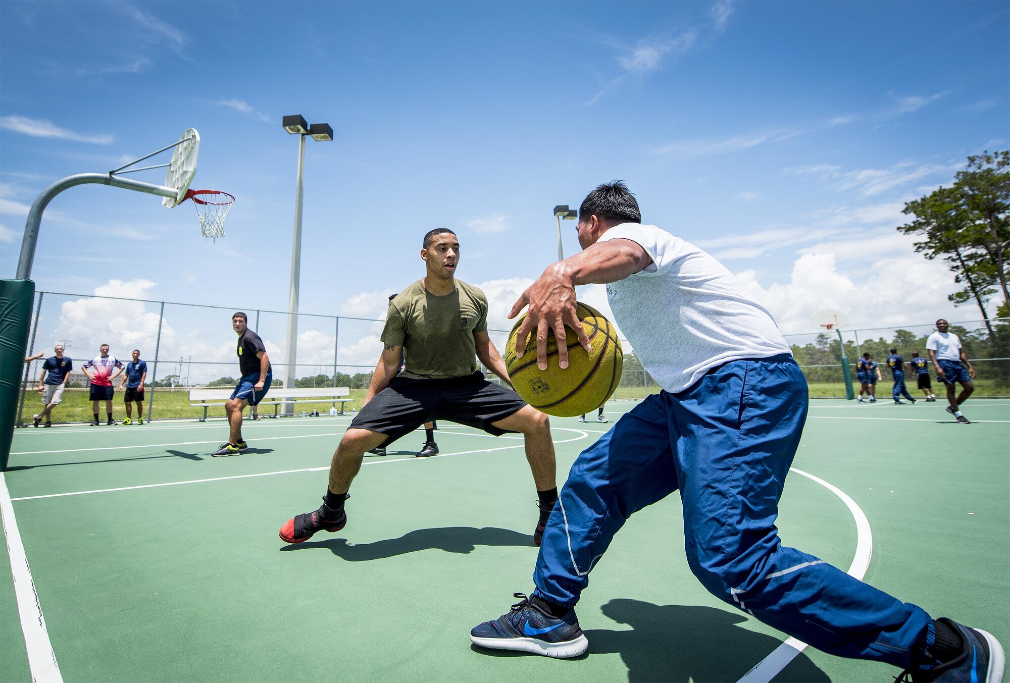 An Airman tries to dribble past a defender at the 3-on-3 basketball tournament that was part of the Eglin Connects event at Eglin Air Force Base, Fla., June 2.  The event to help promote resiliency featured information booths, sporting events and a car show.  (U.S. Air Force photo/Samuel King Jr.)