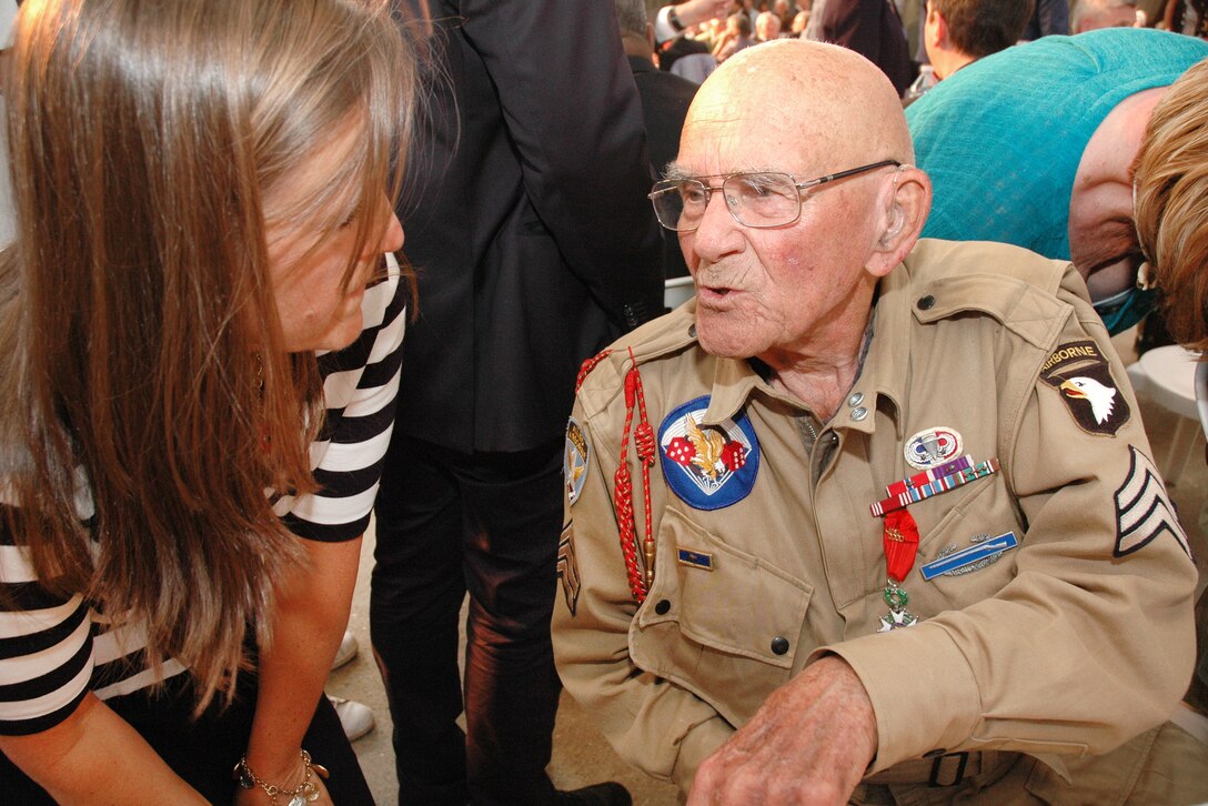 A woman thanks World War II veteran Bob Noody for his service during a dinner in Sainte-Mere-Elise, France, June 3, 2017. Army photo by Master Sgt. Sean McCollum