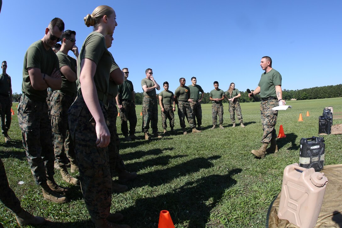 Gunnery Sgt. Anthony Stockman briefs a group of Marines assigned to Marine Aircraft Group 29, 2nd Marine Aircraft Wing, about the rules of the M-16A4 service rifle assembly and disassembly relay race at Marine Corps Air Station New River, N.C., May 26, 2017. The race included a low crawl to a rifle where one Marine would disassemble the rifle and crawl back. Then the next Marine would crawl and reassemble the weapon. Alongside the events, MAG-29 conducted classes and guided discussions to assist Marines with identifying and preparing to mitigate upcoming risk during the summer months. Stockman is the MAG-29 personnel support detachment first sergeant. (U.S. Marine Corps photo by Pfc. Skyler Pumphret/Released)