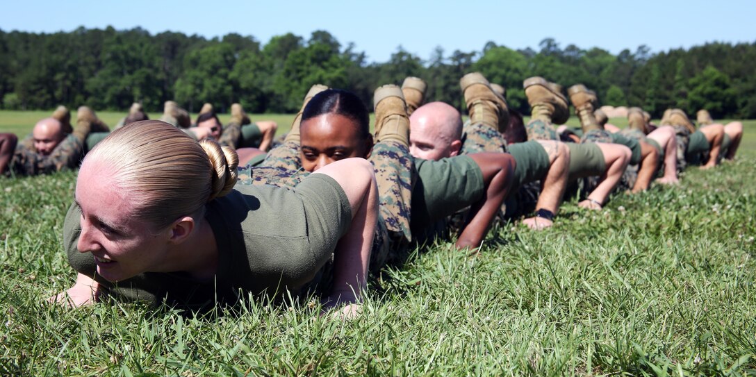 Members of Marine Aircraft Group 29, 2nd Marine Aircraft Wing, prepare to conduct a squad push-up challenge during a semi-annual field meet at Marine Corps Air Station New River, N.C., May 26, 2017. Alongside the events, MAG-29 conducted classes and guided discussions to assist Marines with identifying and preparing to mitigate upcoming risk during the summer months. (U.S. Marine Corps photo by Pfc. Skyler Pumphret/Released)