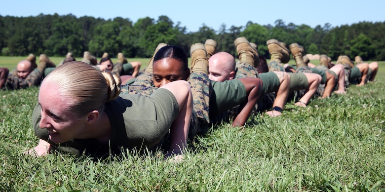 Members of Marine Aircraft Group 29, 2nd Marine Aircraft Wing, prepare to conduct a squad push-up challenge during a semi-annual field meet at Marine Corps Air Station New River, N.C., May 26, 2017. Alongside the events, MAG-29 conducted classes and guided discussions to assist Marines with identifying and preparing to mitigate upcoming risk during the summer months. (U.S. Marine Corps photo by Pfc. Skyler Pumphret/Released)