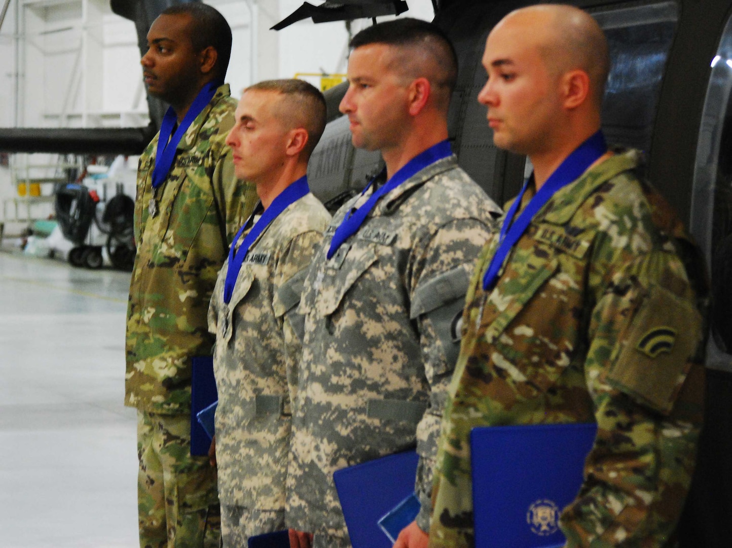 Four New York Army National Guard Soldiers who received New York's highest medal for heroism, the Medal for Valor, stand in formation during award ceremonies on Sunday, June 4, 2017 at Army Aviation Support Facility # 1 in Ronkonkoma, N.Y. The men were recognized for rescuing the pilot of a light plane which crashed in flames on Feb. 26. They are, from left, Sgt. Yaanique Scott, Warrant Officer Christopher Hansen, Chief Warrant Officer 2 Aaron Pacholk and Chief Warrant Officer 2 Ronald Ramirez.