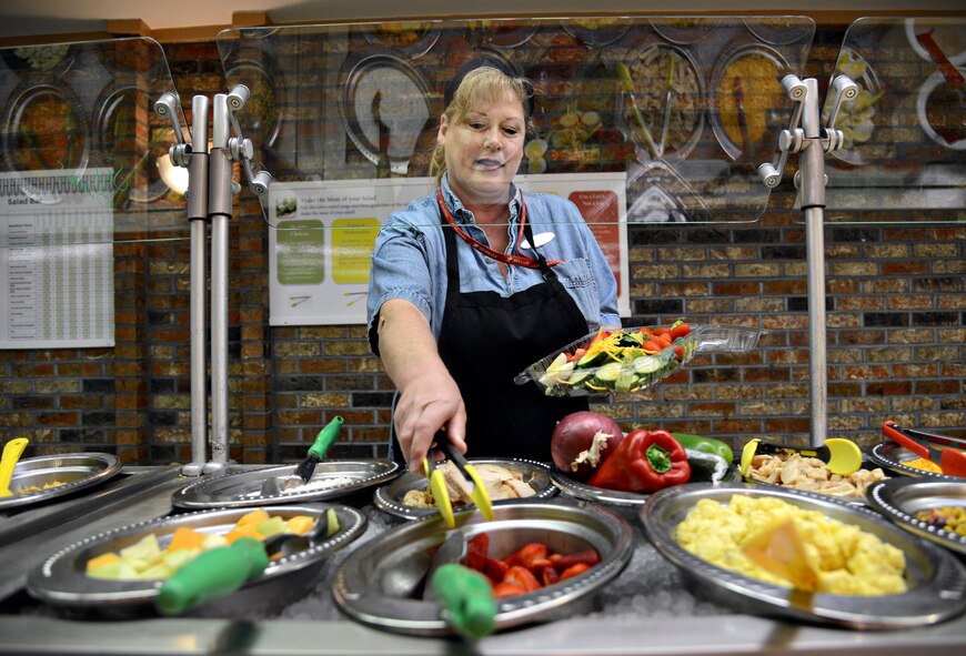 Karen Dubbe, a cashier at Cafe 3001, assembles a colorful salad for her lunch. The tongs for each food item on the salad bar have either a green, yellow or red handle, based off the "Look for the Leaf" concept for nutrition awareness, allowing the customers to be knowledgeable about healthy food selections.