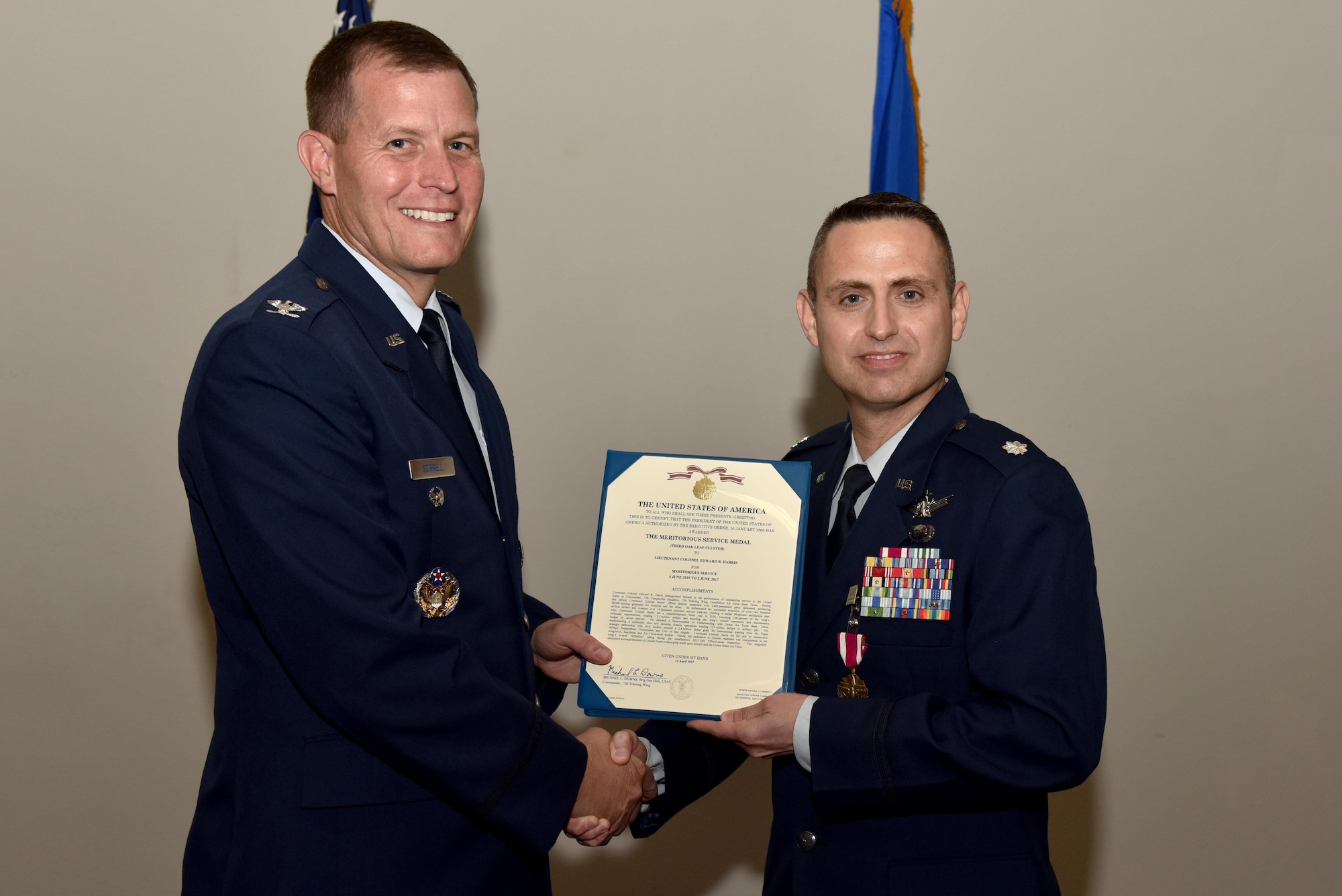 U.S. Air Force Col. Jeffery Sorrell, 17th Training Wing Vice Commander, presents a Meritorious Service certificate to Lt. Col. Edward Harris, 17th Comptroller Squadron Commander, during the 17th CPTS Change of Command ceremony at the Event Center on Goodfellow Air Force Base, Texas, June 2, 2017. The event honored Harris’ service to his unit and welcomed its new commander Maj. Nelson Mitchell. (U.S. Air Force photo by Staff Sgt. Joshua Edwards/Released)
