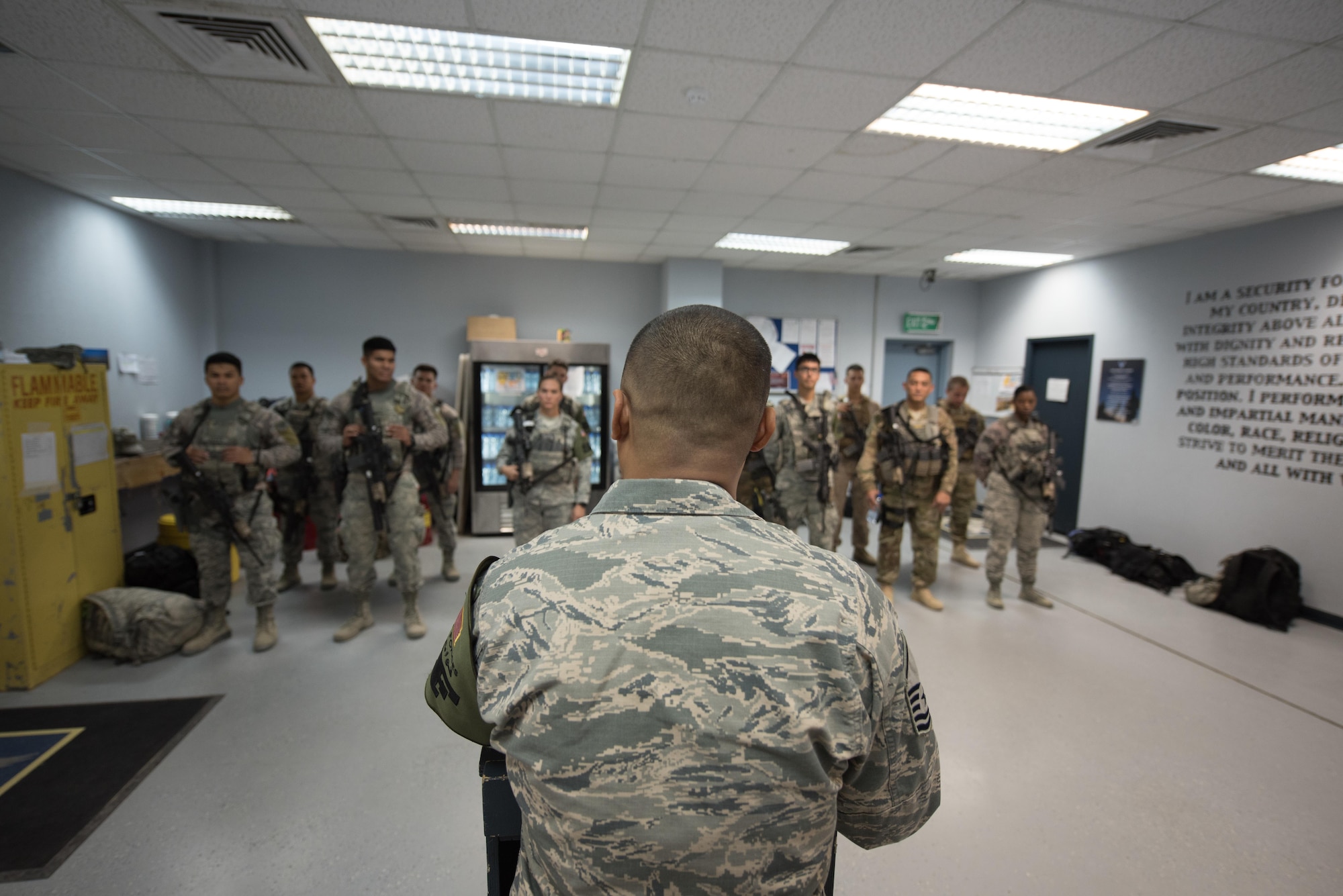 U.S. Air National Guard U.S. Air Force Master Sgt. Oscar Espinosa, 407th Expeditionary Security Forces flight chief, gives instructions to Airmen and U.S. Marines during a guardmount briefing May 10, 2017, in Southwest Asia. Espinosa, a guardsman with the 254th Security Forces Squadron from Andersen Air Force Base, deployed in support of Operation Inherent Resolve. As flight chief, Espinosa coordinates gate guard and patrol teams from both services and international coalition members. (U.S. Air Force photo by Staff Sgt. Alexander W. Riedel)