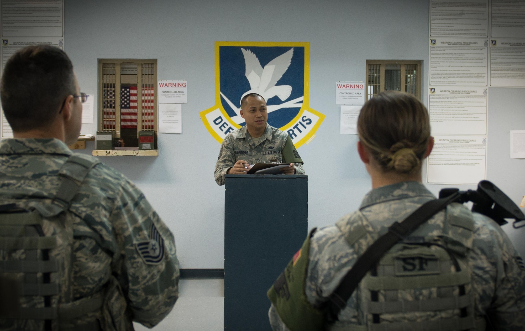 U.S. Air National Guard Master Sgt. Oscar Espinosa, 407th Expeditionary Security Forces flight chief, center, gives instructions to Airmen and U.S. Marines during a guardmount briefing May 10, 2017, in Southwest Asia. Espinosa, a guardsman with the 254th Security Forces Squadron from Andersen Air Force Base, deployed in support of Operation Inherent Resolve. As flight chief, Espinosa coordinates gate guard and patrol teams from both services and international coalition members. (U.S. Air Force photo by Staff Sgt. Alexander W. Riedel)