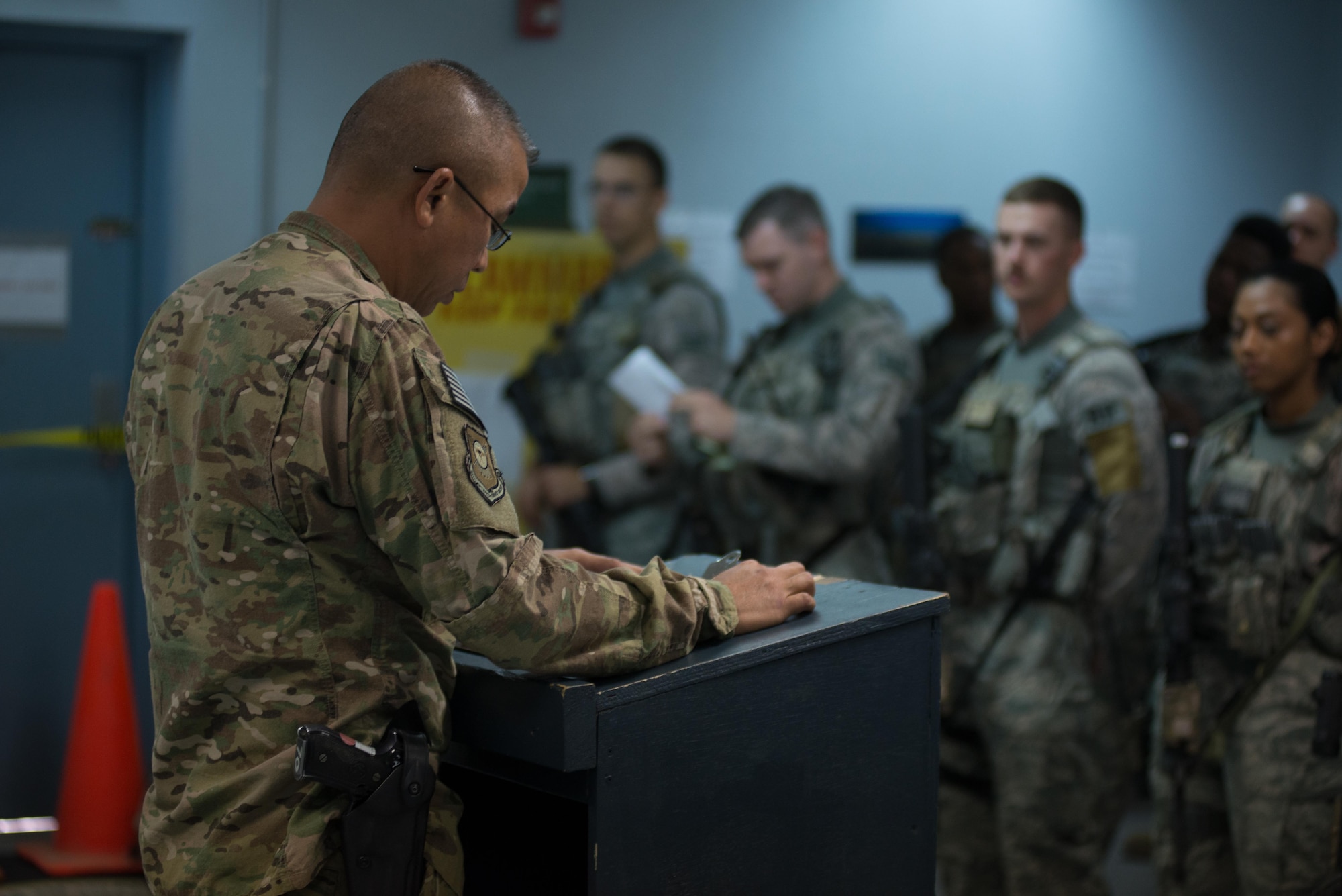 U.S. Air National Guard Master Sgt. Anthony Arriola, flight chief with the 407th Expeditionary Security Forces Squadron, left, briefs Airmen and U.S. Marines during guard changeover May 13, 2017, in Southwest Asia. Arriola works as part of the base defense operations center to oversee inegrated base defense activities, from patrols to vehicle search and gate guard sections. Arriola is deployed from the 254th Security  Forces Squadron of the Guam Air National Guard and serves as a civilian police officer with the Guam Police Department when not on active Air Force orders. (U.S. Air Force photo by Staff Sgt. Alexander W. Riedel)