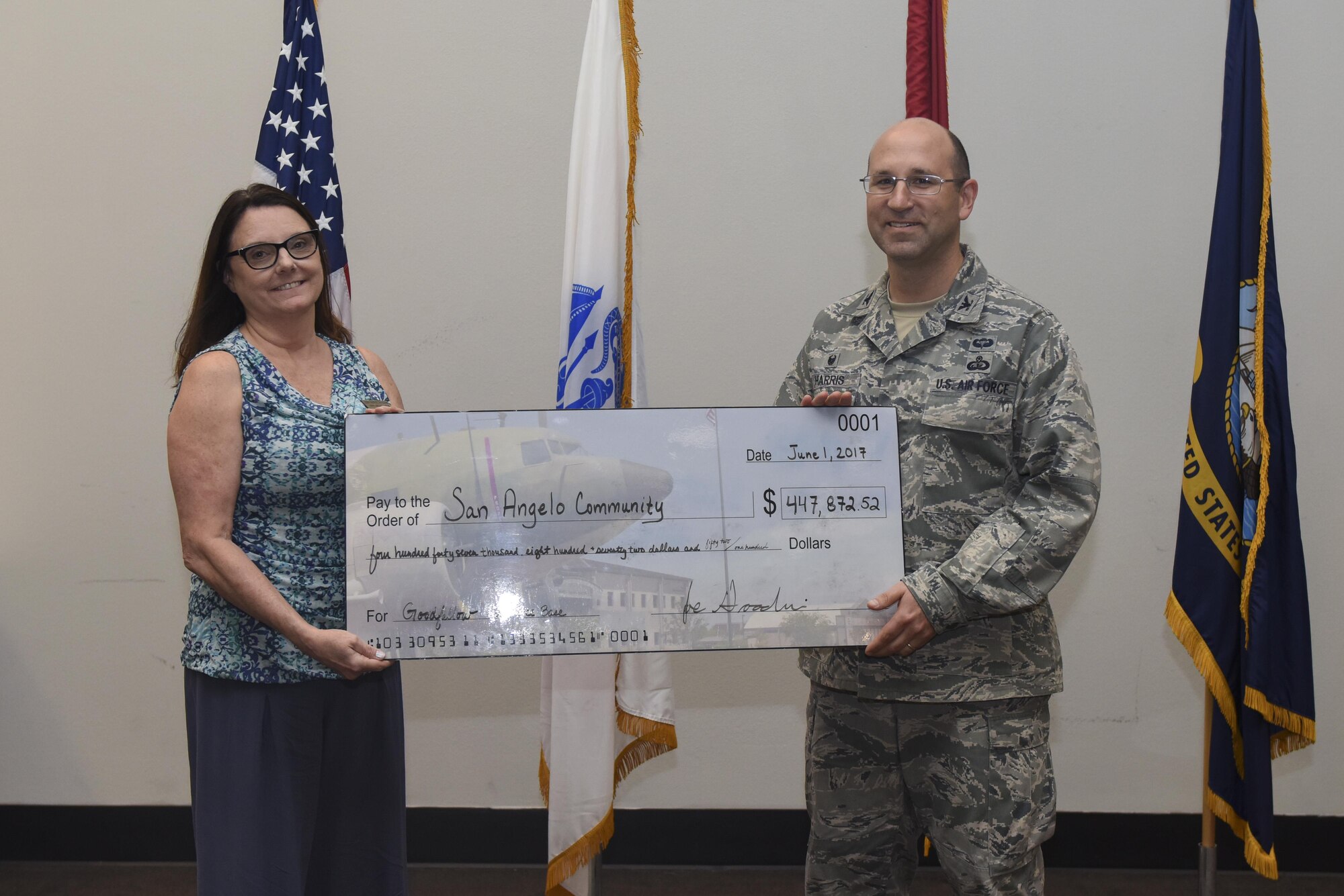 U.S. Air Force Col. Christopher Harris, 17th Mission Support Group Commander, accepts a symbolic check at the Event Center on Goodfellow Air Force Base, Texas, June 1, 2017. The check is a representation of how much the community has saved through Goodfellow volunteers. (U.S. Air Force photo by Airman 1st Class Chase Sousa/Released)