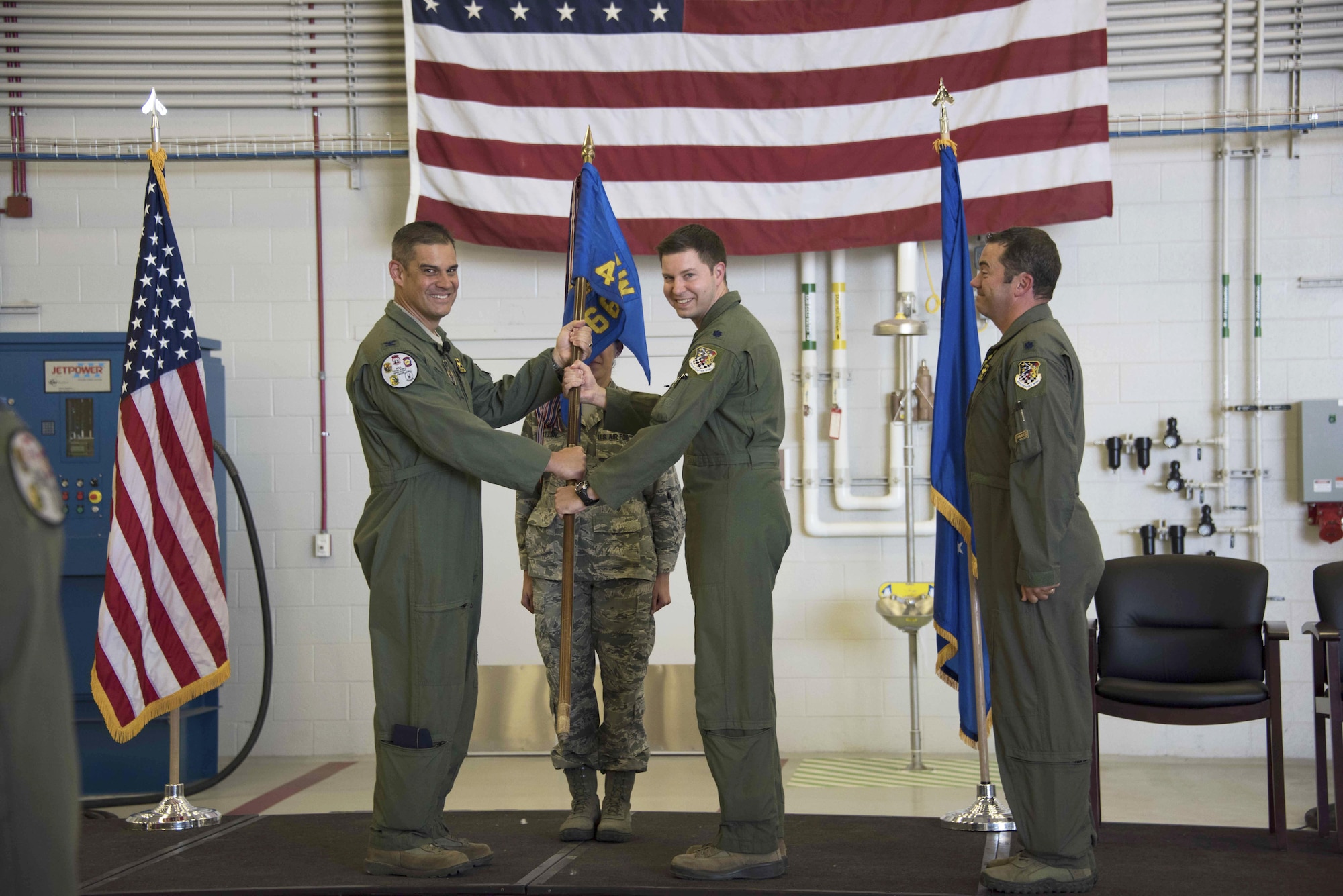 Col. David Castaneda (left), 419th Operations Group commander, passes the 466th Fighter Squadron flag to Lt. Col. Dave DeAngelis during a change of command ceremony at Hill Air Force Base, Utah, June 4. “We take a big step today as we move through the transition to the F-35,” Castaneda said. (U.S. Air Force photo/Senior Airman Justin Fuchs)