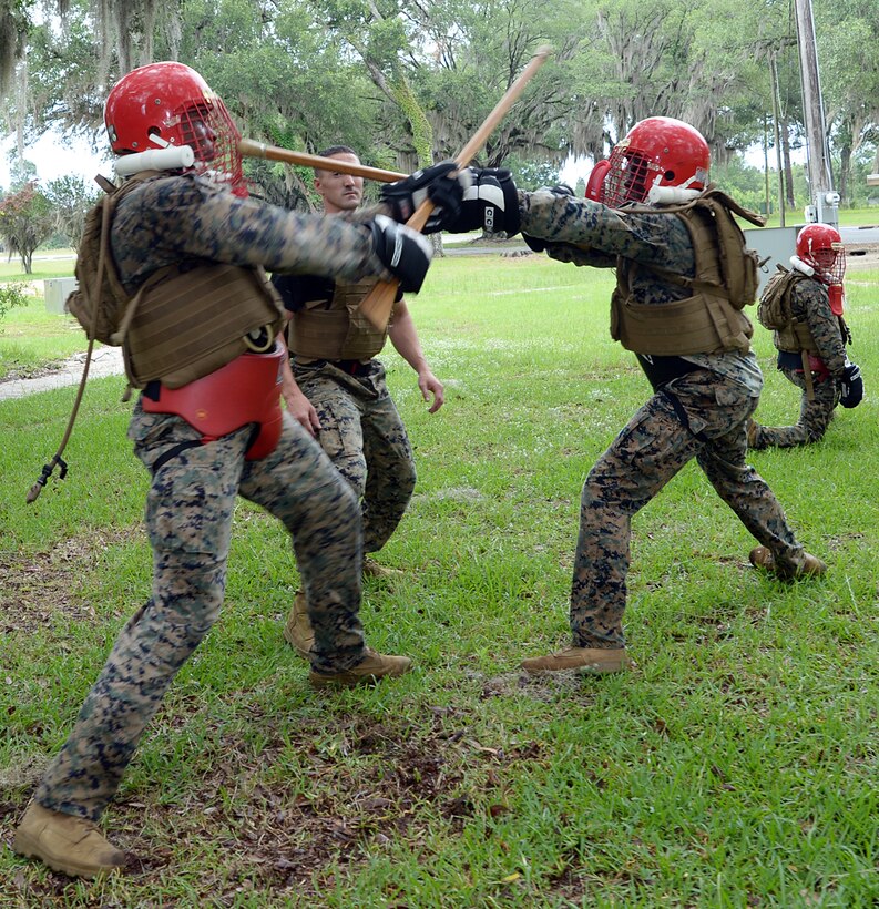 Martial arts instructor students Sgt. Marquis Jones, right, and Sgt. Frederick Graham, fight in a weapons-free sparring match under the watchful eye of Sgt. James M. Ahearn, martial arts instructor trainer, during a Martial Arts Instructor Course aboard Marine Corps Logistics Base Albany, May 24.