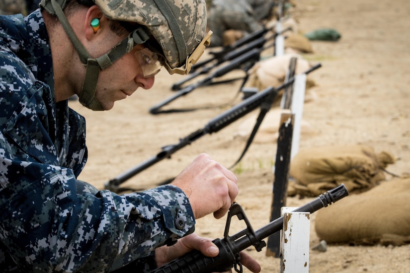 Ensign David Segala, an Engineer Duty Officer from New London, CT adjusts his front sights during joint training at Fort Devens, MA. Navy junior officers received skills training from Army drill sergeants during a joint training exercise to better prepare for future deployments June 3, 2017.