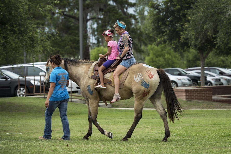 Attendees take ride on a pony during the Moody Summer Block Party, June 2, 2017, at Moody Air Force Base, Ga. Members of Team Moody were encouraged to attend the event which offered a plethora of activities for all ages, including water slides, volleyball tournaments, a car show, and live entertainment. (U.S. Air Force photo by Senior Airman Janiqua P. Robinson)