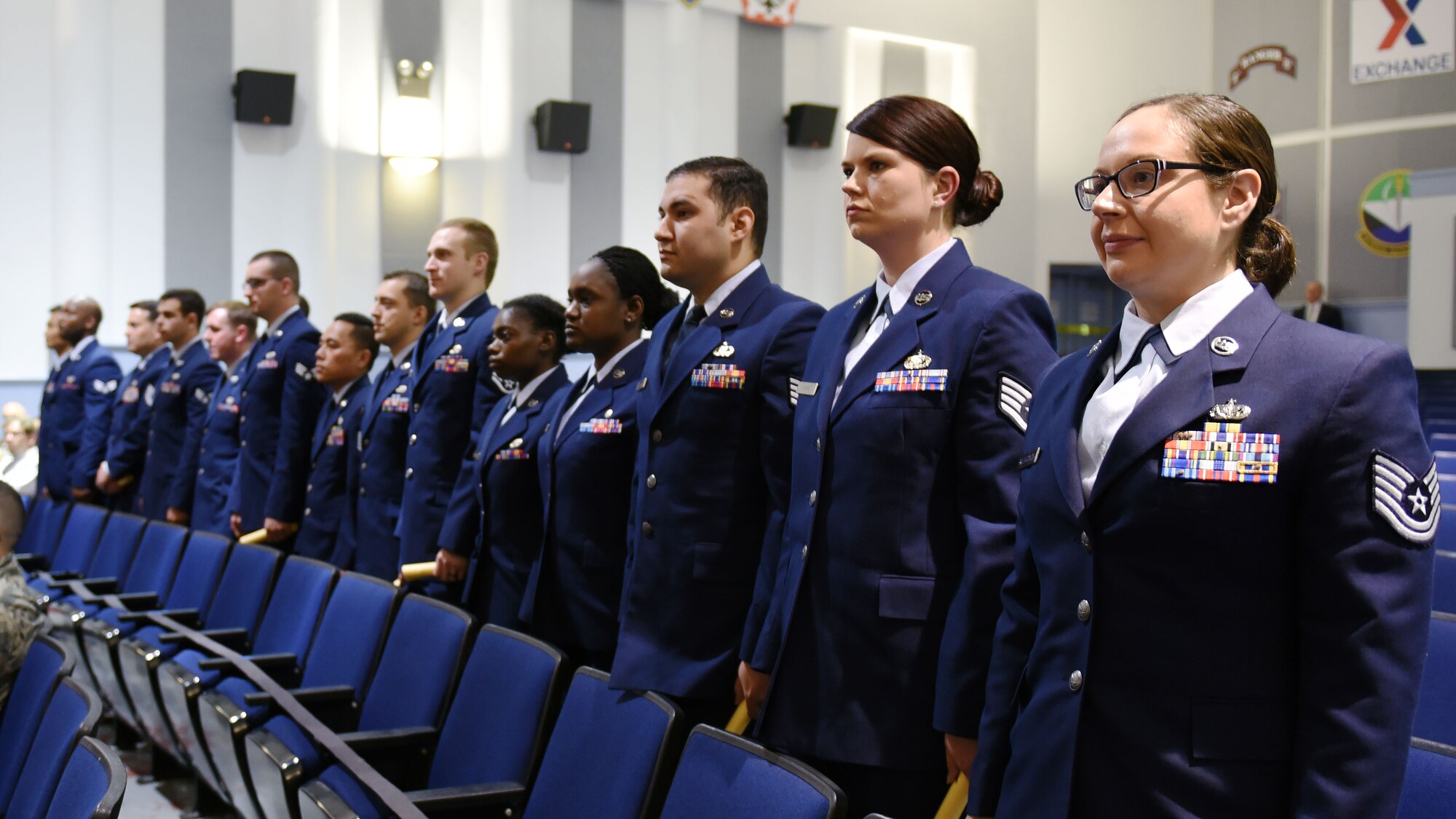 Graduates of the Community College of the Air Force stand during their commencement ceremony, June 2, 2017 at the McChord Theater at Joint Base Lewis-McChord, Wash. Dozens of Team McChord members joined the ranks of the more than 500,000 Airmen who have earned Associate of Arts degrees through the CCAF. (U.S. Air Force photo/Staff Sgt. Whitney Taylor)