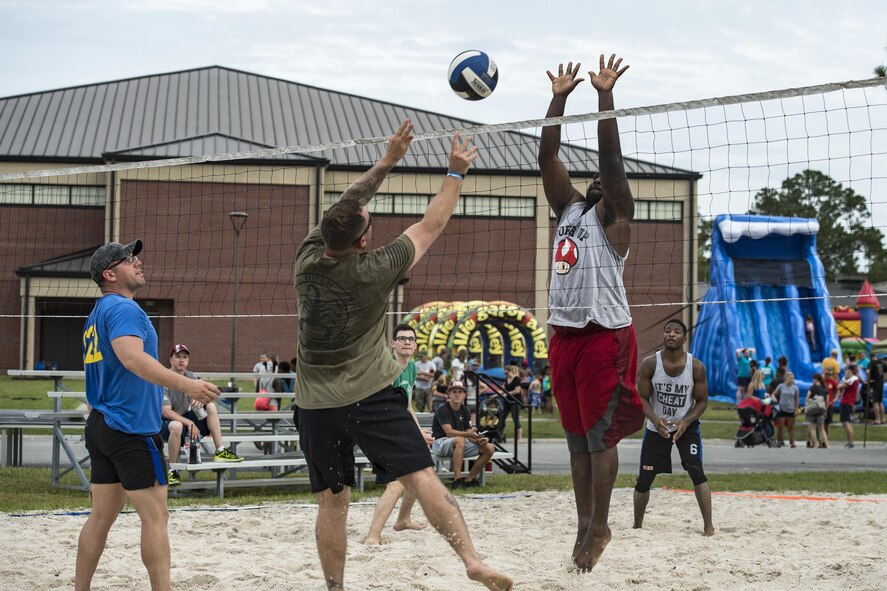 Competitors vie for a volleyball during the tournament portion of the Moody Summer Block Party, June 2, 2017, at Moody Air Force Base, Ga. Members of Team Moody were encouraged to attend the event which offered a plethora of activities for all ages, including water slides, volleyball tournaments, a car show, and live entertainment. (U.S. Air Force photo by Senior Airman Janiqua P. Robinson)