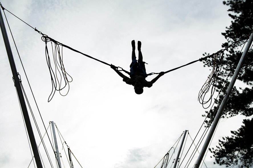 An attendee preforms a back flip on an attraction during the Moody Summer Block Party, June 2, 2017, at Moody Air Force Base, Ga. Members of Team Moody were encouraged to attend the event which offered a plethora of activities for all ages, including water slides, volleyball tournaments, a car show, and live entertainment. (U.S. Air Force photo by Senior Airman Janiqua P. Robinson)