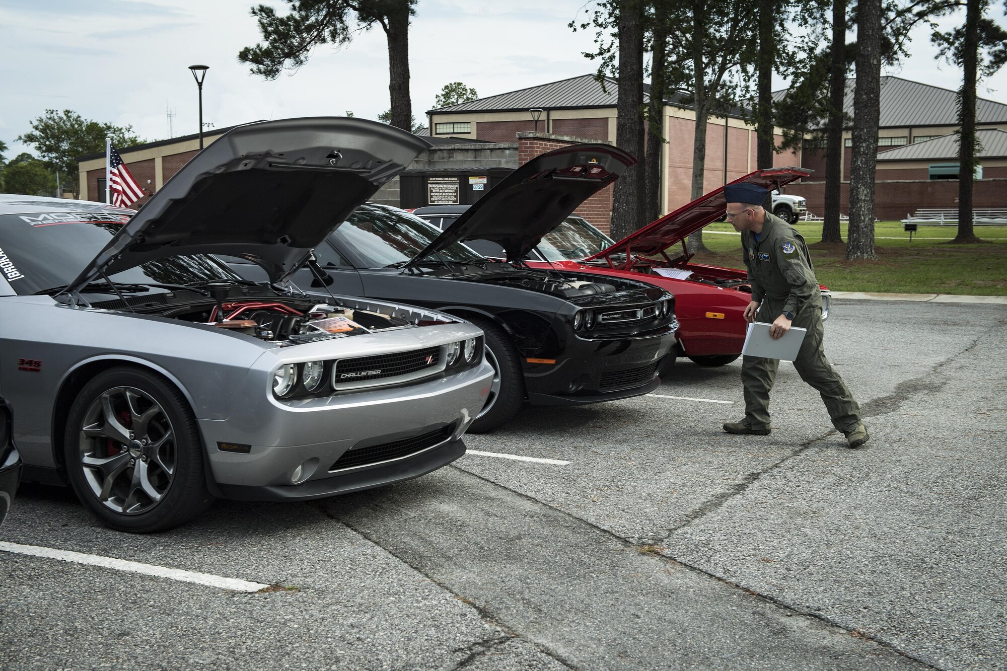 A judge looks under the hood of several cars during the car show portion of the Moody Summer Block Party, June 2, 2017, at Moody Air Force Base, Ga. Members of Team Moody were encouraged to attend the event which offered a plethora of activities for all ages, including water slides, volleyball tournaments, a car show, and live entertainment. (U.S. Air Force photo by Senior Airman Janiqua P. Robinson)
