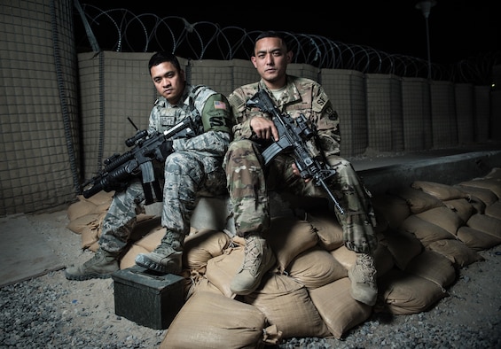 U.S. Air National Guard Staff Sgts. Neil Carranza (left) and Ricky Meno, security forces supervisors with the 407th Expeditionary Security Forces Squadron, sit for a photo May 10, 2017, at the 407th Air Expeditionary Group. The Airmen ensures only authorized personnel and vehicles enter the installation by providing vehicle search and additional overwatch via towers, cameras and other sensors at the 407th AEG. Both are traditional guardsmen with the 254th Security Forces Squadron at Andersen Air Force Base, Guam, deployed in support of Operation Inherent Resolve. (U.S. Air Force photo by Staff Sgt. Alexander W. Riedel)