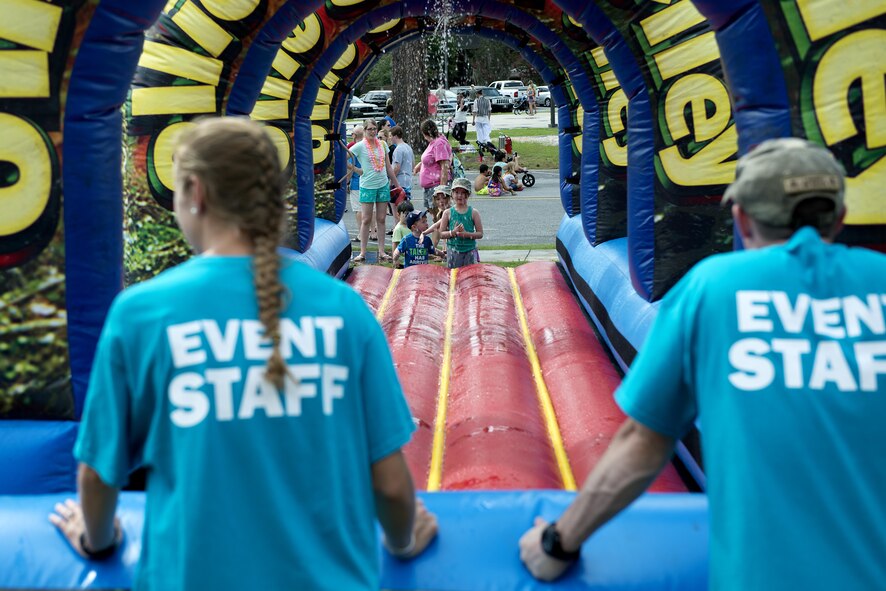 A participant gets ready to slide on a water obstacle during the Moody Summer Block Party, June 2, 2017, at Moody Air Force Base, Ga. The event featured different attractions including water obstacles, horse rides and live entertainment. (U.S. Air Force photo by Airman 1st Class Erick Requadt)