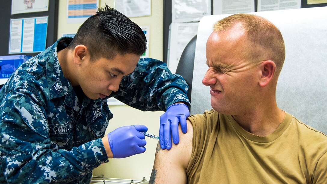 Navy Petty Officer 2nd Class Charles Scheck winces as Petty Officer 3rd Class Gerich Curtom administers a flu shot at Naval Air Station North Island’s medical clinic in Coronado, Calif., June 3, 2017. Scheck is a builder and Curtom is a hospital corpsman. Navy photo by Petty Officer 1st Class Sean P. Lenahan