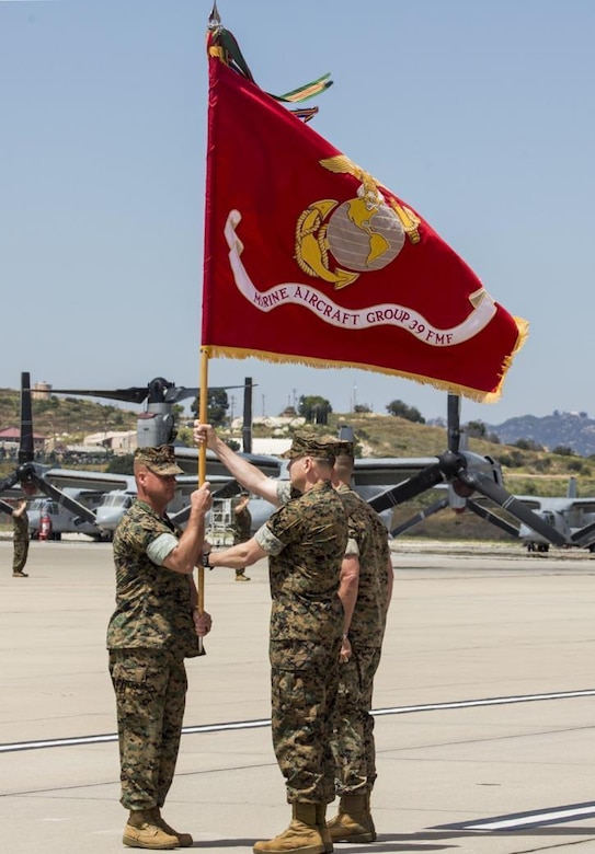 Sgt. Maj. Chad Butts passes the Marine Air Group (MAG) 39 colors to Col. Matthew Mowery on the flightline at Marine Corps Air Station Camp Pendleton, Calif., during the MAG-39 change of command ceremony, May 25. During the ceremony, command of MAG-39 changed hands from Col. Michael Borgschulte to Col. Matthew Mowery. (U.S. Marine Corps photo by Lance Cpl. Liah Smuin/Released)