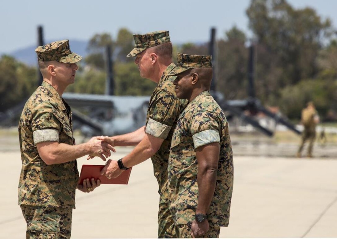 Maj. Gen. Mark Wise, middle, the 3rd Marine Aircraft Wing commanding general presents Col. Michael Borgschulte, the outgoing Marine Aircraft Group (MAG) 39 commanding officer with the legion of merit on the flightline at Marine Corps Air Station Camp Pendleton, Calif., during the MAG-39 change of command ceremony, May 25. During the ceremony, command of MAG-39 changed hands from Col. Michael Borgschulte to Col. Matthew Mowery. (U.S. Marine Corps photo by Lance Cpl. Liah Smuin/Released)