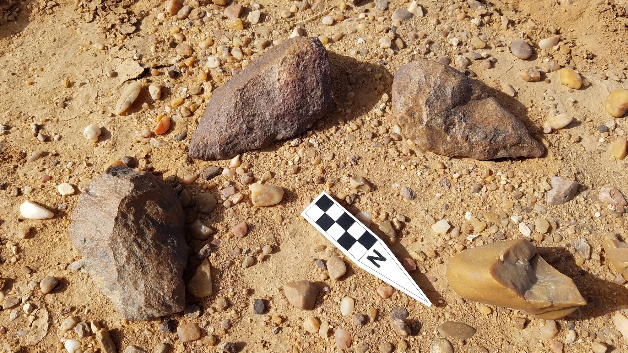 Acheulean tools, dating as far back as 1.76 million years ago in Africa and portions of the Asian continent recently discovered by USACE and USAFCEC archeologists. The two axes at the top of the photo are in their original location. 