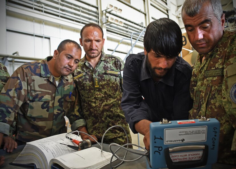 Afghan Air Force MD-530 helicopter level-two maintenance trainers instruct their lower leveled skilled maintenance counterparts on testing procedures of a turbine outlet temperature at Kabul Air Wing, Afghanistan, June 4, 2017. The turbine outlet measures the engine heat and power of the helicopter.  The AAF has three levels of maintenance proficiency, with level one being the highest.  Train, Advise, Assist Command-Air (TAAC-Air) advisors and contractors oversea the training of AAF aircraft maintenance programs as AAF members take lead on hands-on training for new AAF members. (U.S. Air Force photo by Tech. Sgt. Veronica Pierce) 