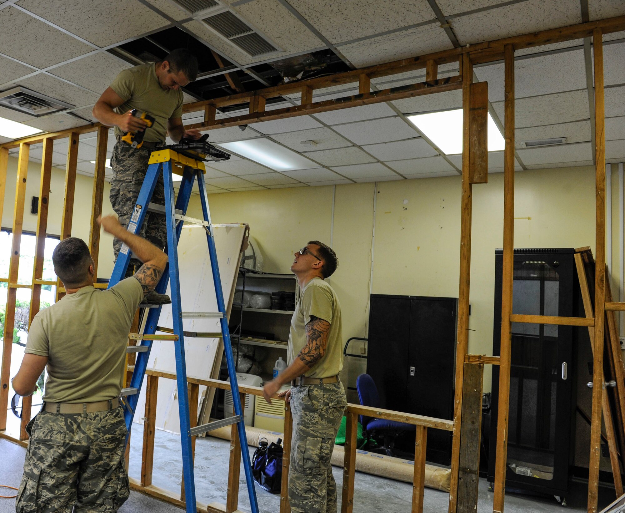 U.S. Air Force Airmen from the 18th Civil Engineer Squadron remove a wall frame from ceiling bearings at the 961st Airborne Air Control Squadron May 17, 2017, at Kadena Air Base, Japan. The 18th CES structures Airmen ensure Kadena’s buildings have enough space for units to safely and efficiently conduct mission operations. (U.S. Air Force photo by Senior Airman Lynette M. Rolen)