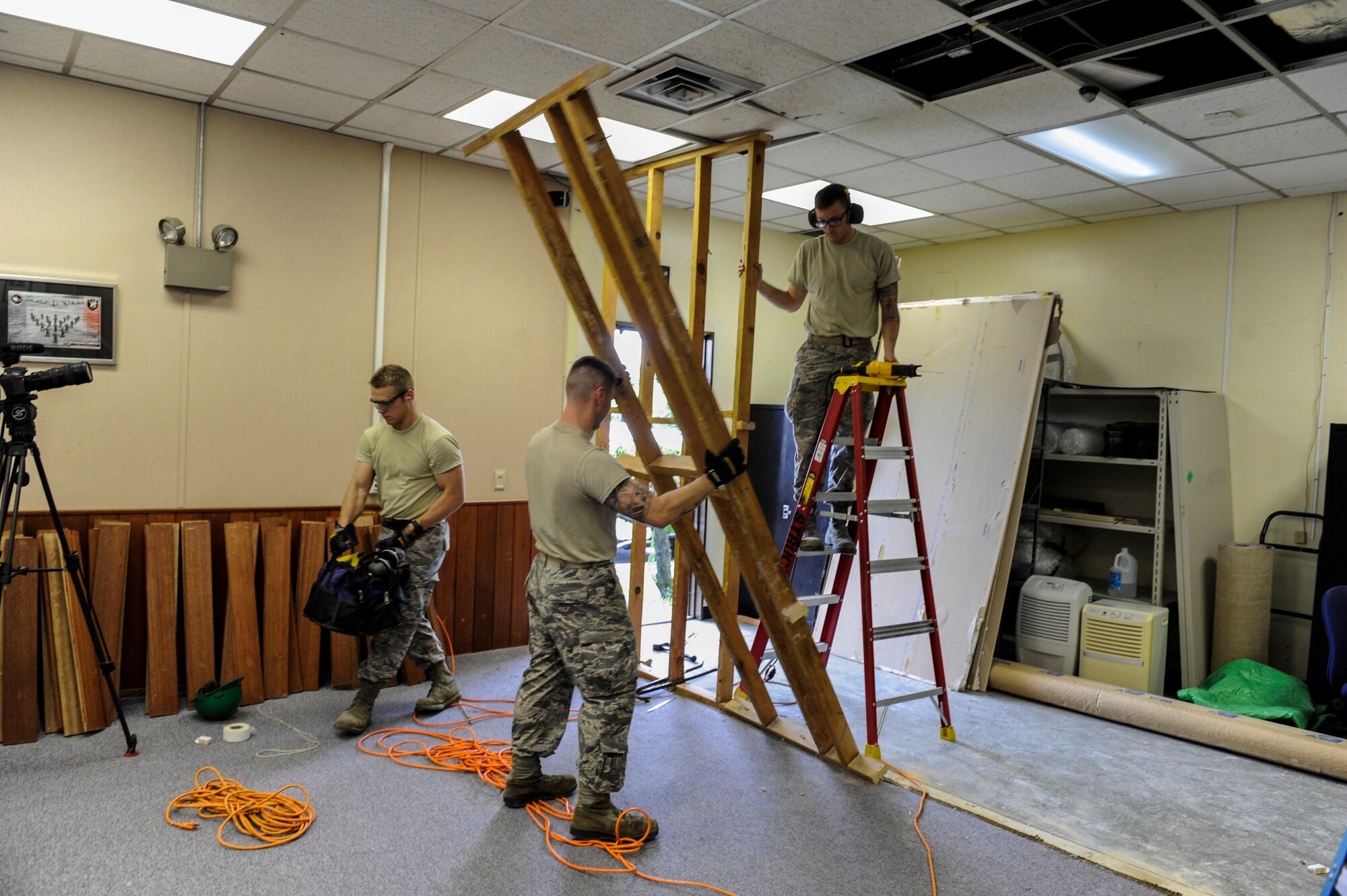 U.S. Air Force Airmen from the 18th Civil Engineer Squadron remove a portion of a wall frame as part of a workspace expansion project at the 961st Airborne Air Control Squadron May 17, 2017, at Kadena Air Base, Japan. The 18th CES structures Airmen ensure Kadena’s buildings meet safety standards and are mission-capable. (U.S. Air Force photo by Senior Airman Lynette M. Rolen)