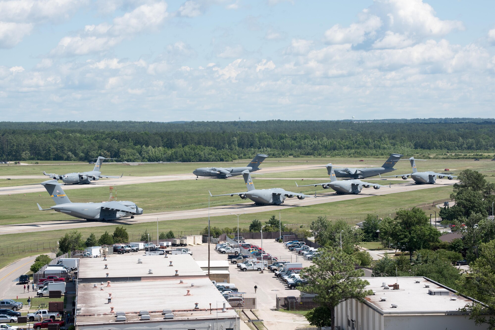 POPE ARMY AIRFIELD, N.C. -- Seven C-17 Globemaster IIIs from the 437th Airlift Wing at Joint Base Charleston, S.C., prepare for takeoff during the 82nd Airborne Division's All American Week here May 25. The 43d Air Mobility Operations Group supported the 82nd and visiting Air Mobility Command aircrews as they prepared for the annual All American Week airdrop at Sicily Drop Zone on Fort Bragg. The drop was cancelled due to high winds after takeoff from Pope Field. (U.S. Air Force photo/Marc Barnes)