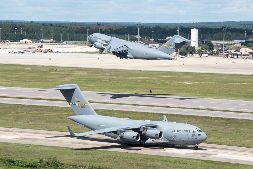 POPE ARMY AIRFIELD, N.C. -- A C-17 Globemaster III from the 437th Airlift Wing at Joint Base Charleston, S.C., launches from the runway here as another taxis for takeoff May 25 during the 82nd Airborne Division's All American Week. The 43d Air Mobility Operations Group supported the 82nd and visiting Air Mobility Command aircrews as they prepared for the annual All American Week airdrop at Sicily Drop Zone on Fort Bragg. The drop was cancelled due to high winds after the aircraft launched from Pope Field. (U.S. Air Force photo/Marc Barnes)