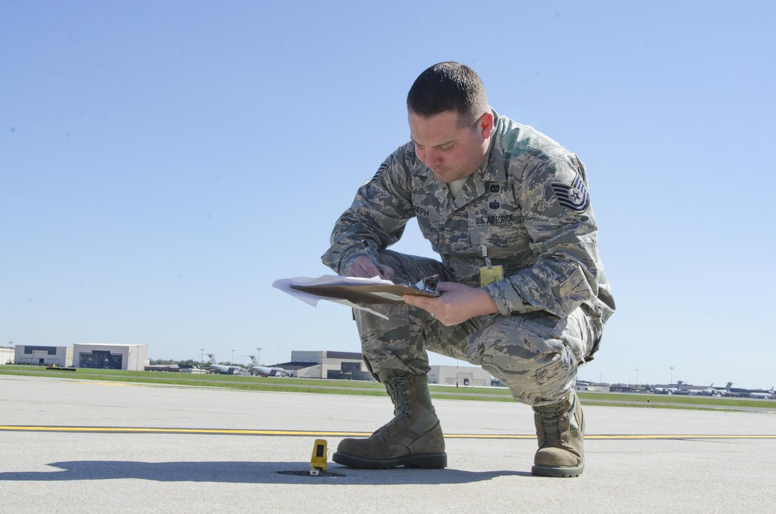 Tech. Sgt. Sean Joseph, Operations Manager 108th Civil Engineer Squadron, Measures a hole in the cement of the108th Aircraft parking ramp, on Joint Base MDL, NJ, April 18, 2017. The holes dimensions and location will be documented and scheduled for repair. (U.S. Air National Guard photo by Staff Sgt. Ross A. Whitley/Released)