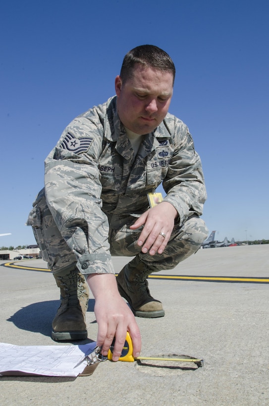 Tech. Sgt. Sean Joseph, Operations Manager 108th Civil Engineer Squadron, Measures a hole in the cement of the108th Aircraft parking ramp, on Joint Base MDL, NJ, April 18, 2017. The holes dimensions and location will be documented and scheduled for repair. (U.S. Air National Guard photo by Staff Sgt. Ross A. Whitley/Released)