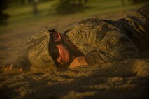 An Airman from the 5th Civil Engineer Squadron low-crawls through a sand pit during an Expeditionary Training Day at Minot Air Force Base, N.D., June 1, 2017. The day-long training event covered an array of combat operations tasks, to help prepare 5th CES Airmen for future deployments. (U.S. Air Force photo/Senior Airman Apryl Hall)