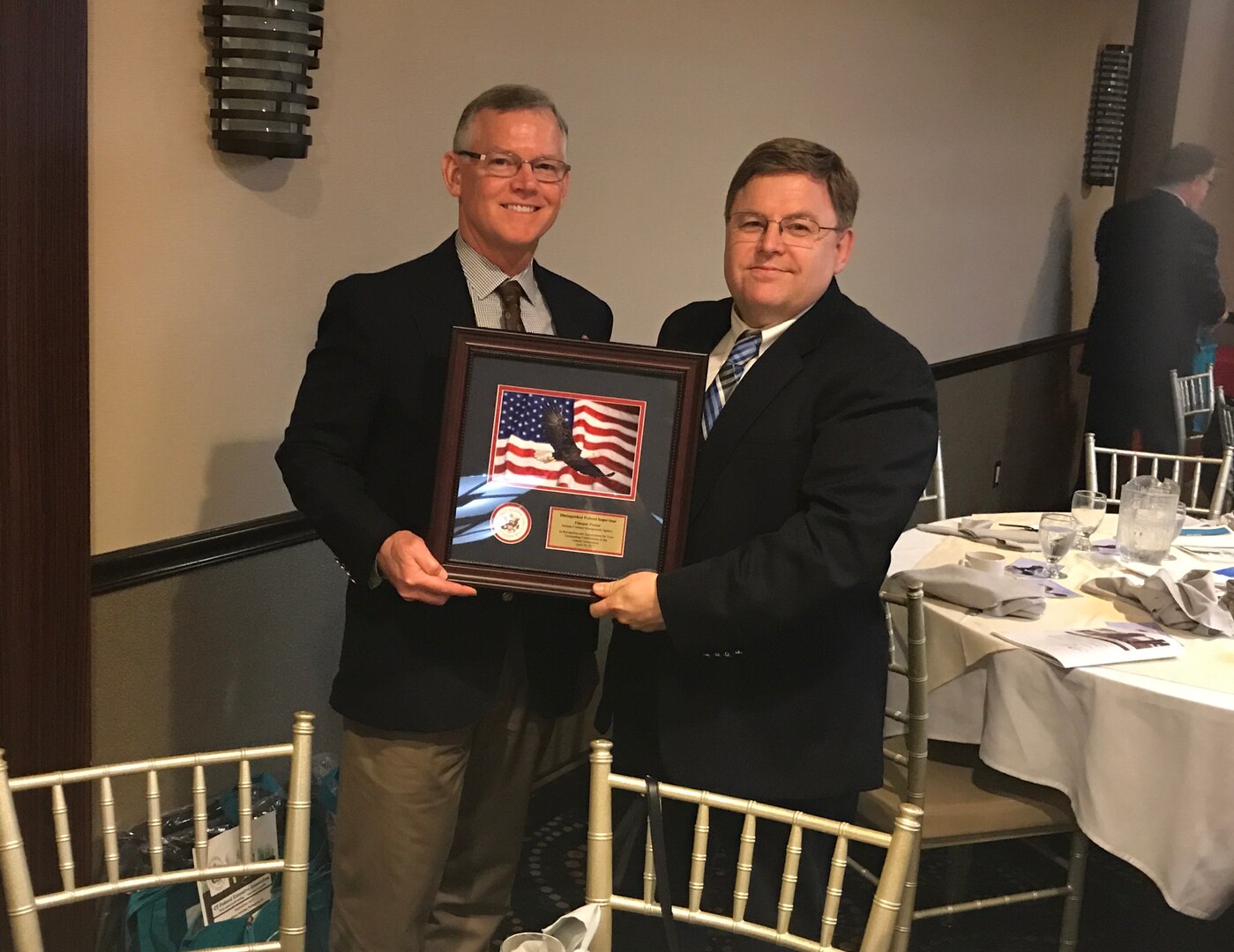 Defense Contract Management Agency Sikorsky Aircraft Stratford employees received recognition during the Excellence in Government Awards Program on April 28 in Berlin, Connecticut. Michael Molkenbuhr (left), engineering and manufacturing team lead, congratulates Vincent Foster, an engineering team lead, for receiving the Distinguished Federal Supervisor award. (Photo by Navy Lt. Cmdr. Rebekah Murtaugh)

