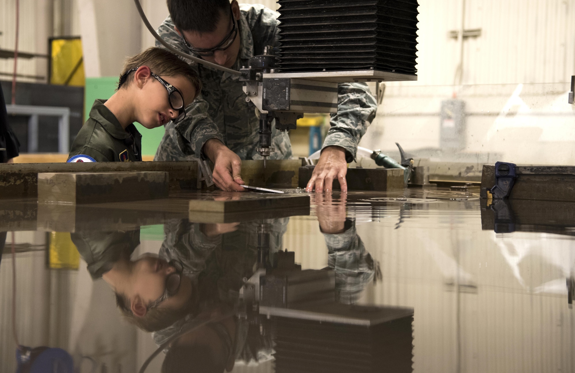 U.S. Air Force Staff Sgt. Nathaniel Ensing, 33rd Aircraft Maintenance Squadron, shows Aidan Flippo, pilot for a day candidate, a piece of metal that was carved May 25, 2017, at Eglin Air Force Base, Florida. Flippo, a 96th Test Wing dependent, was selected to be the 33rd Fighter Wing's pilot for a day. Aidan was born with Septo Optic Dysplasia which effects his eyes and kidneys. During his day, he met F-35 pilots, toured an aircraft, worked with aircraft maintainers and much more. (U.S. Air Force photo by Staff Sgt. Peter Thompson)