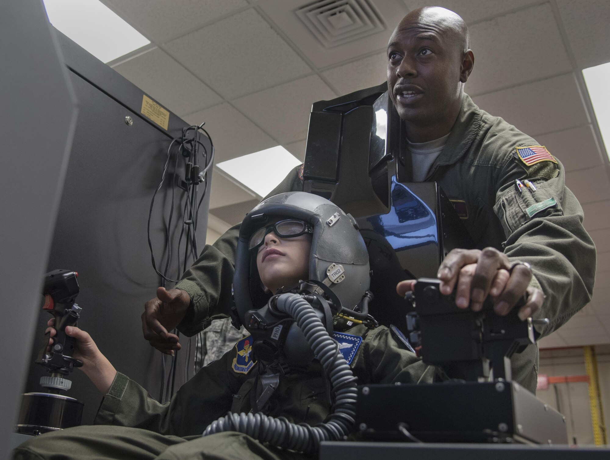 U.S. Air Force Tech. Sgt. Omar Robinson, 96th Aerospace Medicine Squadron, explains a flight simulator to Aidan Flippo, pilot for a day candidate, May 25, 2017, at Eglin Air Force Base, Florida. Flippo, a 96th Test Wing dependent, was selected to be the 33rd Fighter Wing's pilot for a day. Aidan was born with Septo Optic Dysplasia which effects his eyes and kidneys. During his day, he met F-35 pilots, toured an aircraft, worked with aircraft maintainers and much more. (U.S. Air Force photo by Staff Sgt. Peter Thompson)