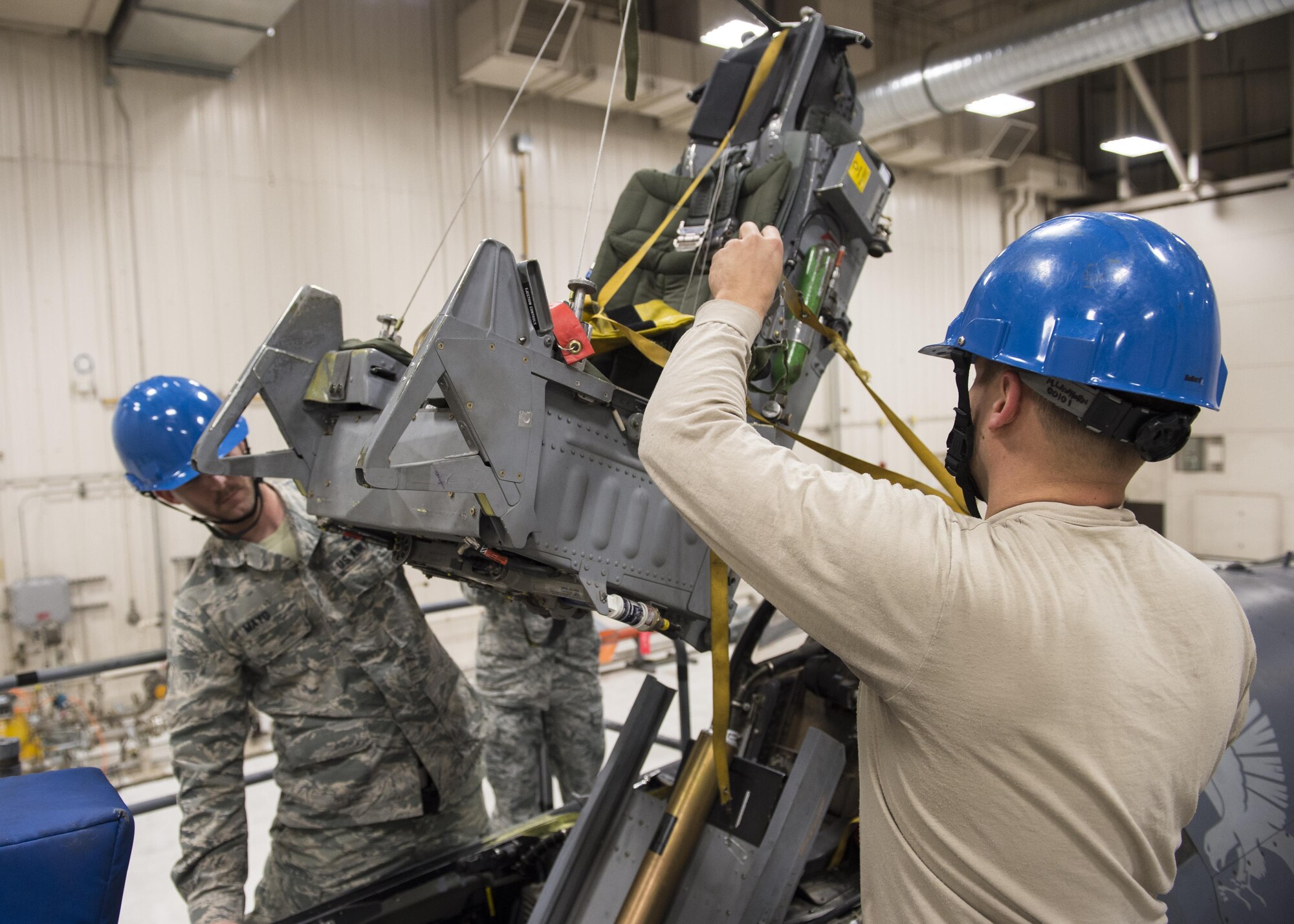 Tech. Sgt. Kevin Mayo (left), the 54th Maintenance Squadron egress section assistant Non-Commissioned Officer in Charge, and Staff Sgt. Mitchell Lawhorn (right), a 54th Maintenance Squadron egress systems Craftsman, remove an ejection seat from an F-16 Fighting Falcon on March 13, 2017 at Holloman Air Force Base, N.M. Egress system specialists ensure that pilots can safely eject from aircraft in the event of an emergency. They perform scheduled and unscheduled maintenance on seats, hatches, canopies and modules to ensure pilots can safely eject if necessary. (U.S. Air Force photo by Senior Airman Emily Kenney)