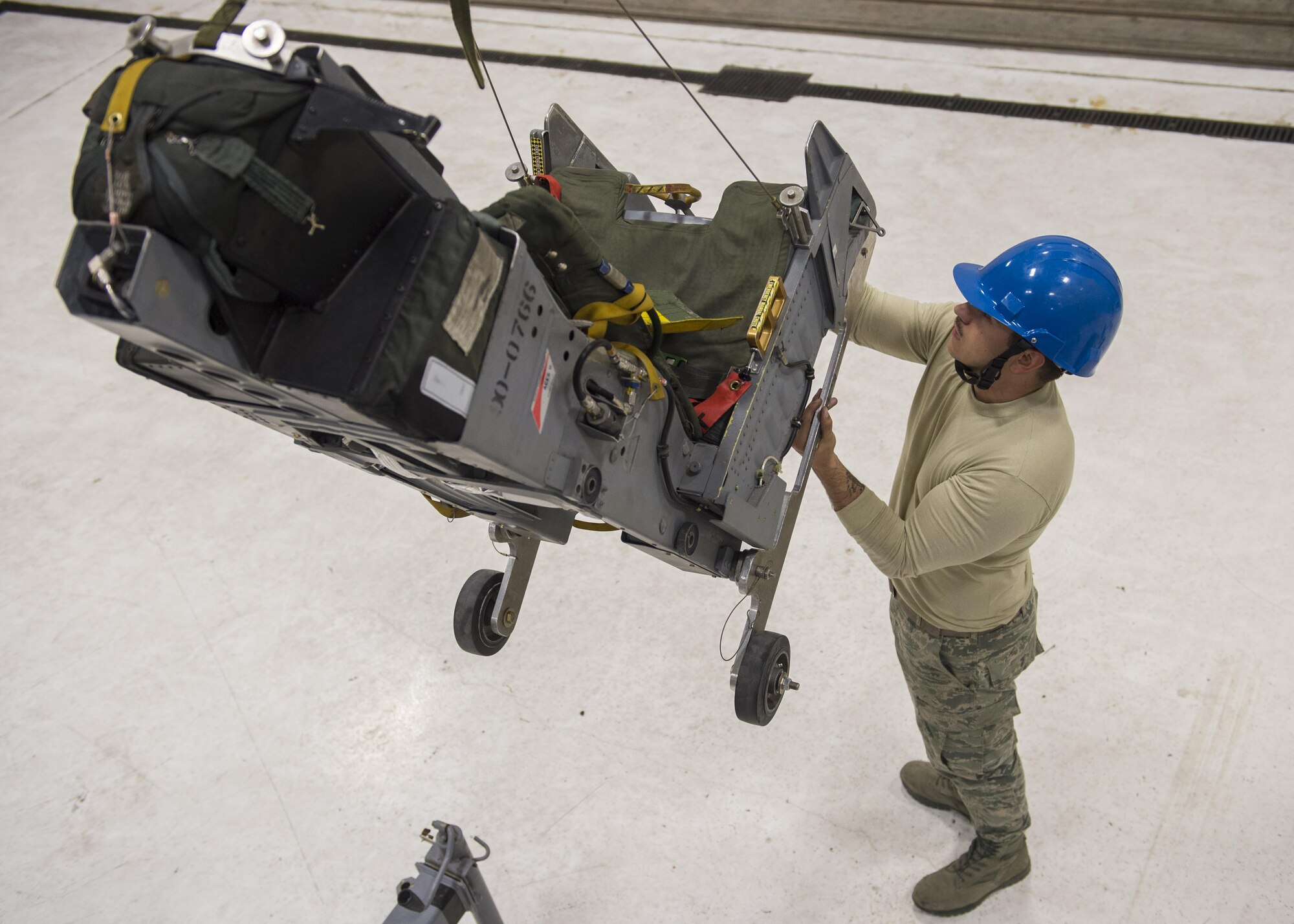 Airman 1st Class Steven Phelps, a 54th Maintenance Squadron egress systems journeyman, removes the ejection seat of an F-16 Fighting Falcon on March 13, 2017 at Holloman Air Force Base, N.M. Egress specialists work hand-in-hand with Aircrew Flight Equipment to ensure pilots have the necessary equipment in case of an emergency. (U.S. Air Force photo by Senior Airman Emily Kenney)